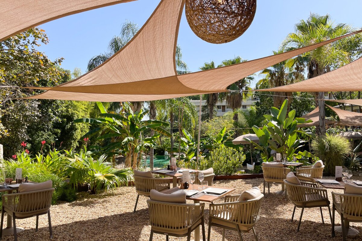 A restaurant with tables and chairs under umbrellas