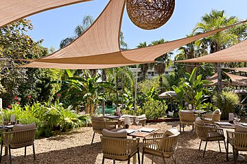 A restaurant with tables and chairs under umbrellas