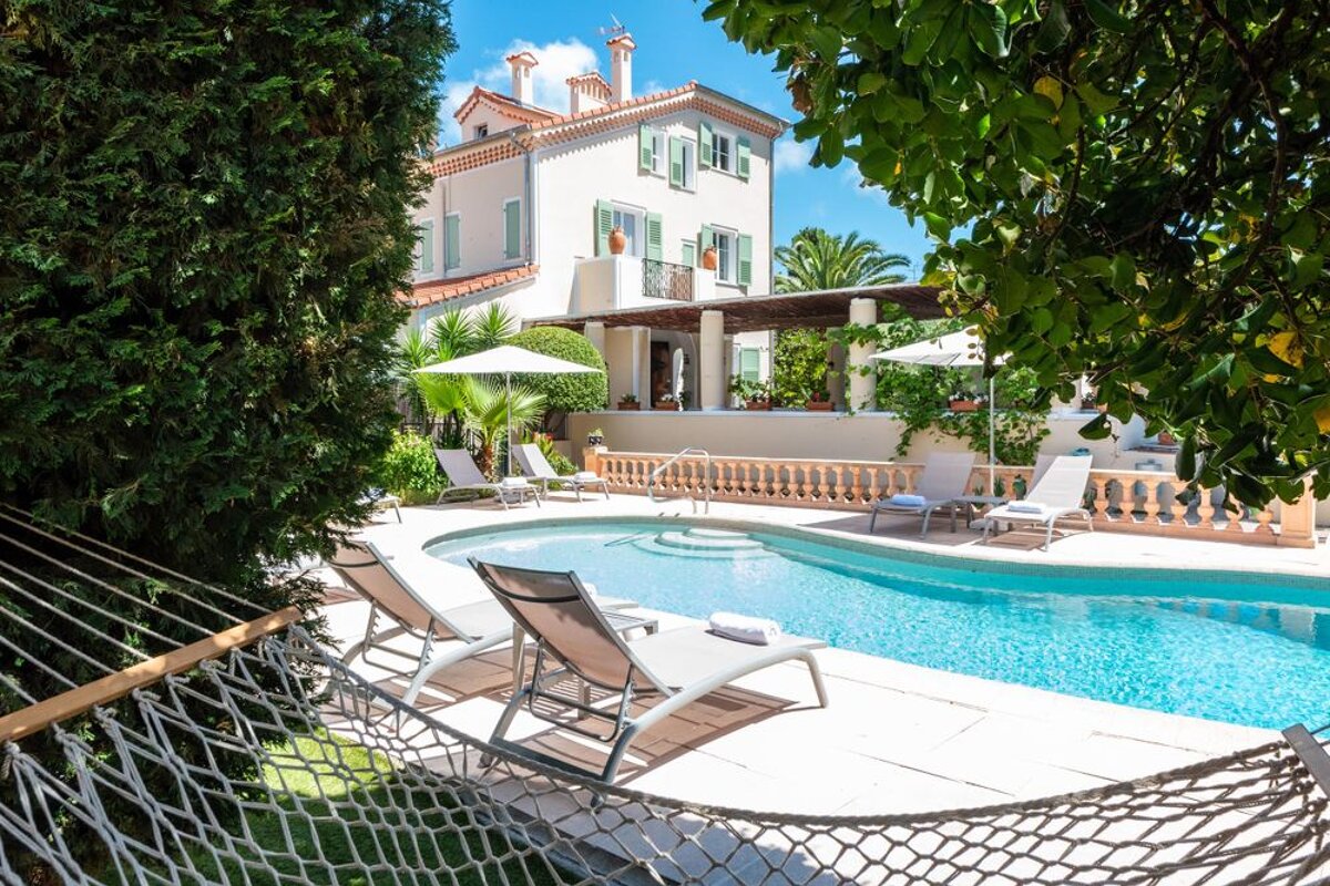 A large white house with a swimming pool in front of it