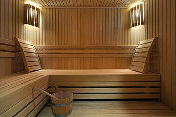 A wooden sauna with a bucket on the floor