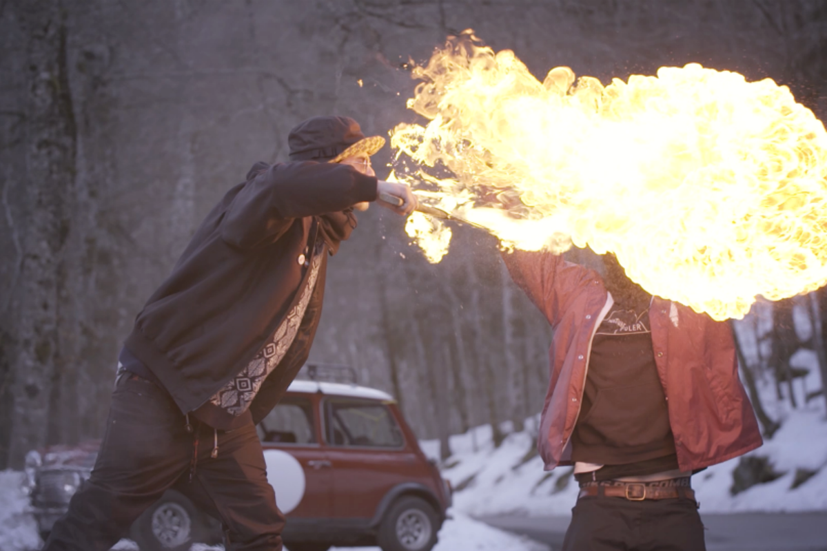 a man breathing fire in front of another man