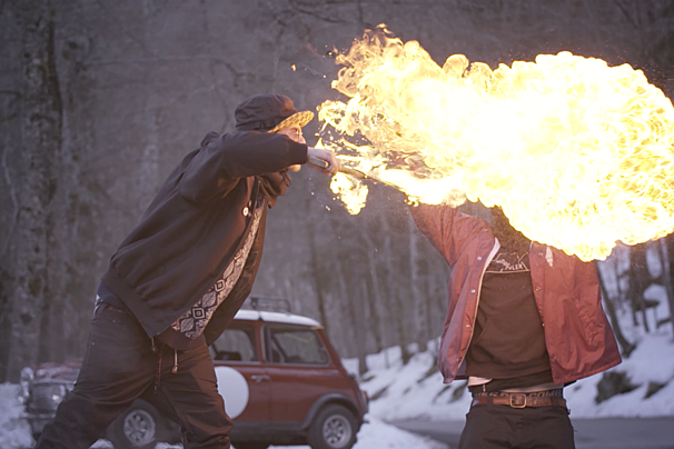 a man breathing fire in front of another man