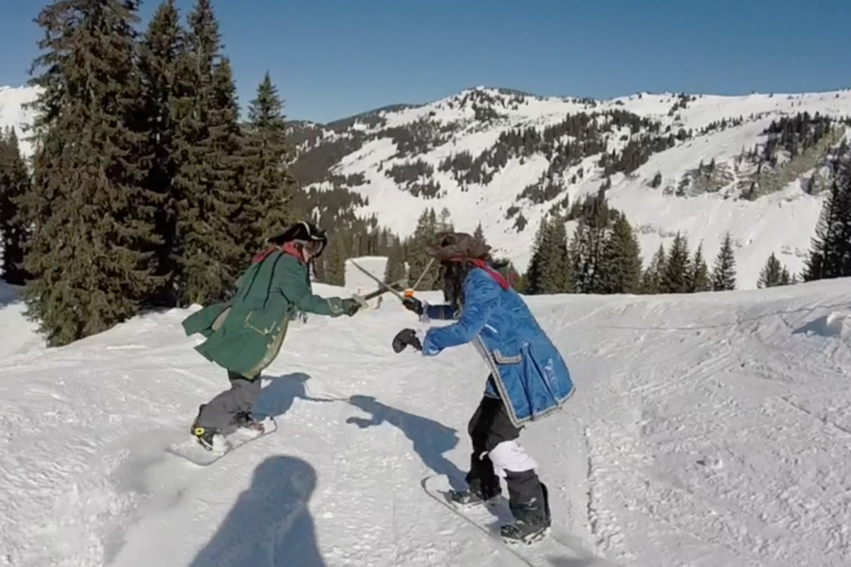 two pirates on snowboards having a swordfight
