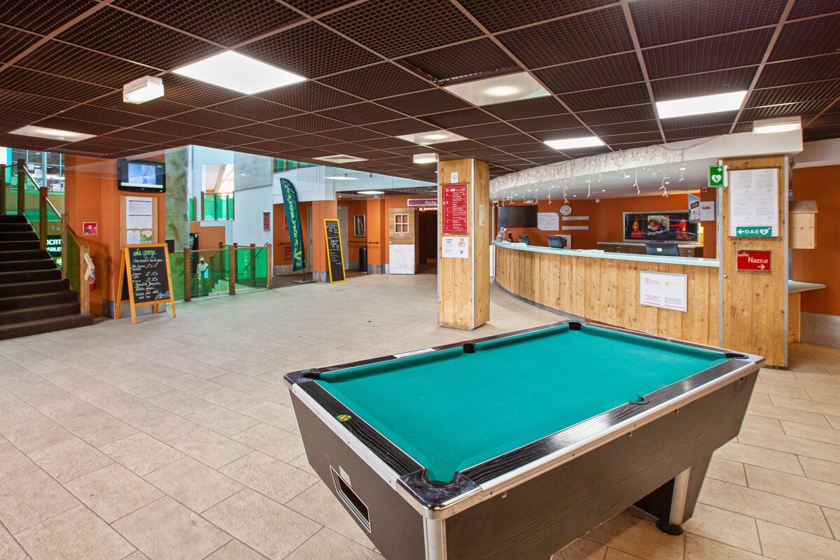 A pool table in a lobby with a sign that says ' ambulance ' on it