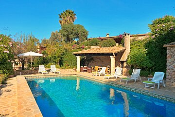 A swimming pool with chairs and umbrellas around it