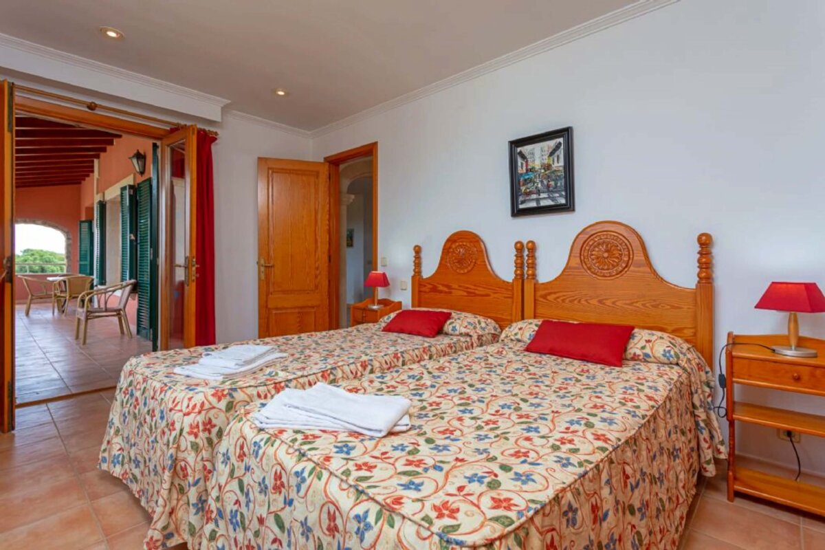 A bedroom with two beds and a picture on the wall