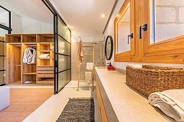 A bathroom with a walk in closet and a sink