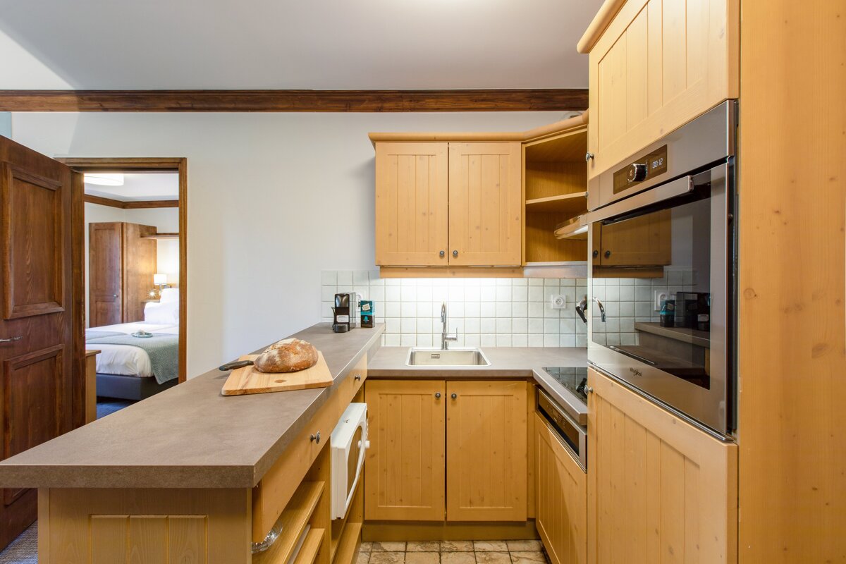 A kitchen with wooden cabinets and a bread loaf on the counter