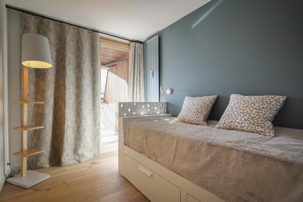 A bed with two pillows and a lamp in a bedroom