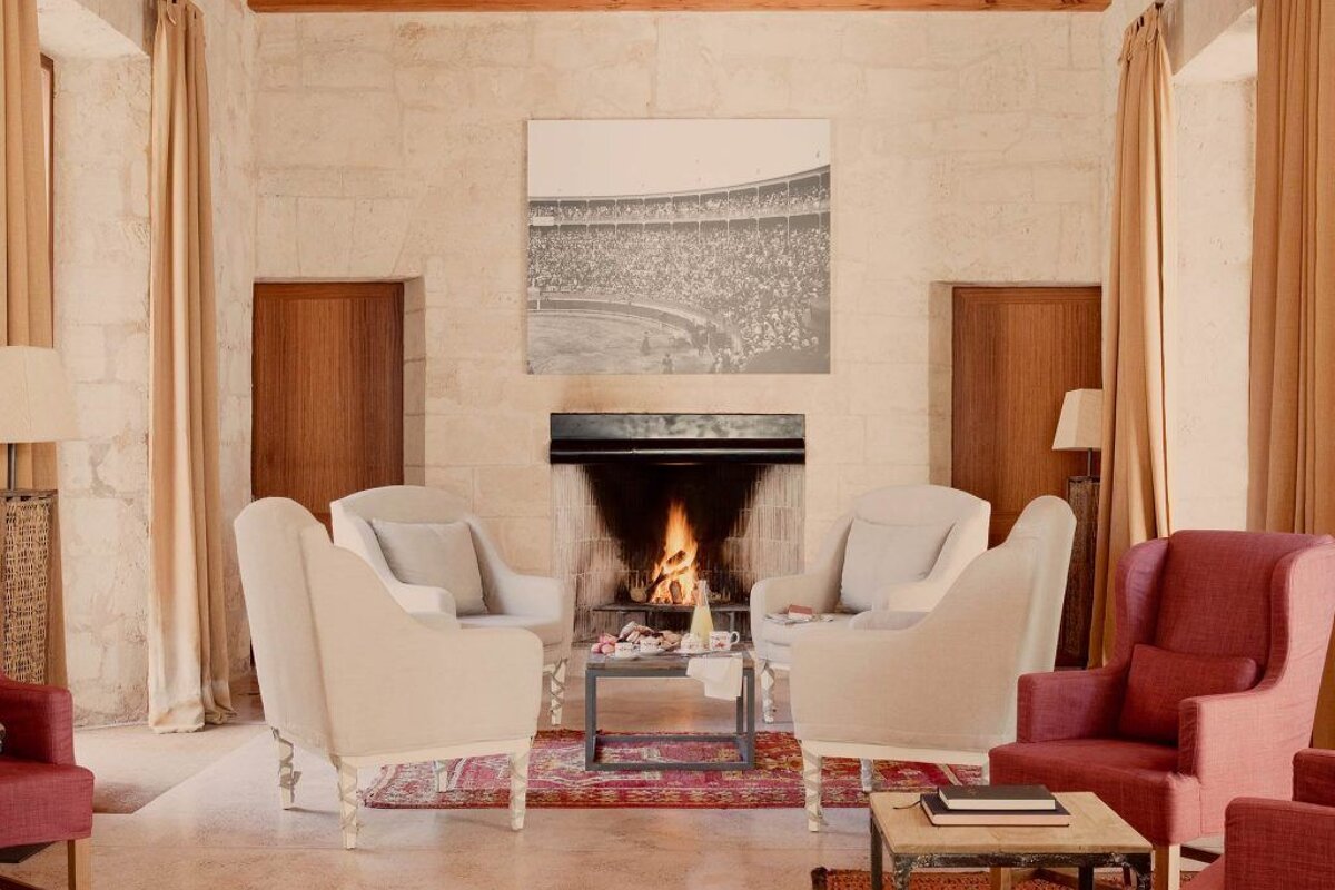 A living room with white chairs and a fireplace
