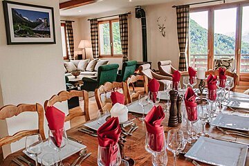 A dining room table with red napkins and white plates