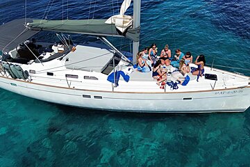 A group of people are sitting on the deck of a sailboat that says 6 at 6-3016