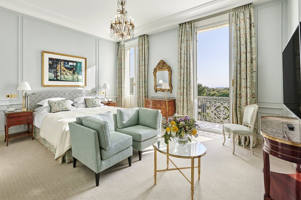 A hotel room with a balcony and a large bed