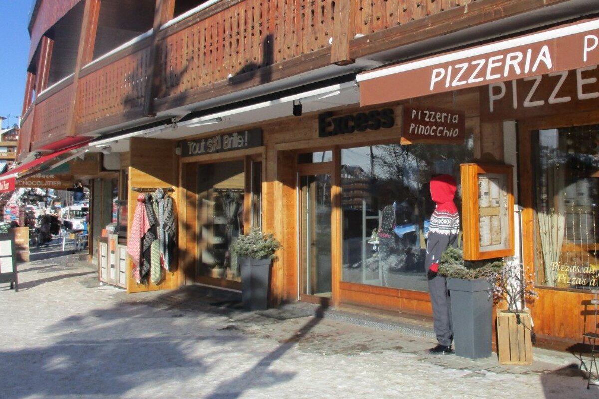 a shop next to a pizzeria