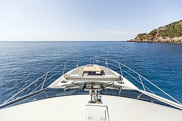 The front of a boat in the ocean with a table on the bow
