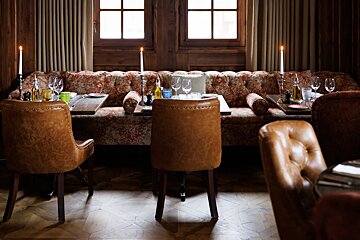 A dining room with tables and chairs and candles