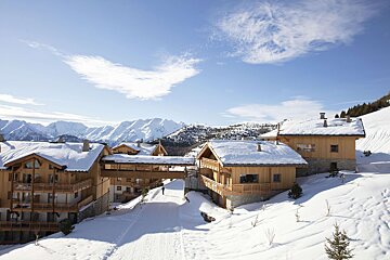 Snow covered buildings with mountains in the background