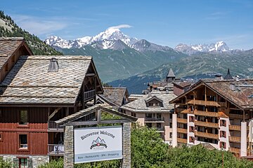 A sign that says bienvenue welcome in front of a mountain