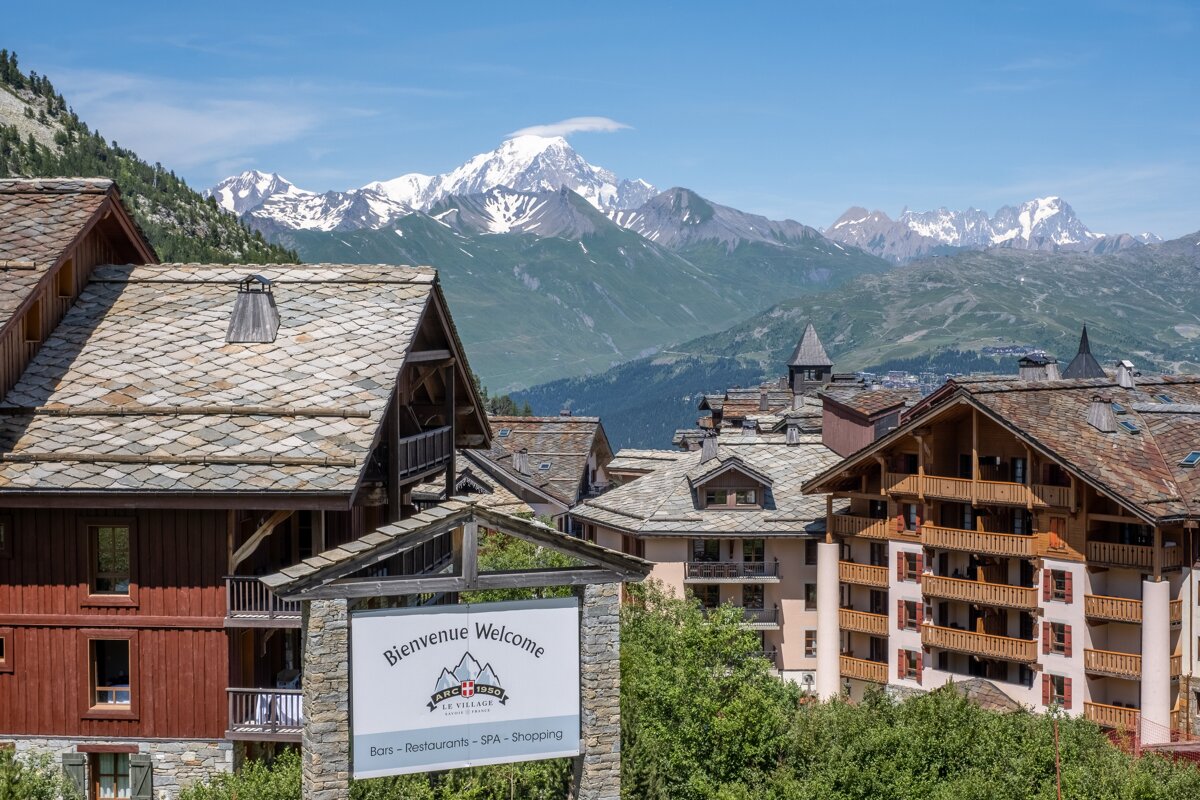A sign that says bienvenue welcome in front of a mountain