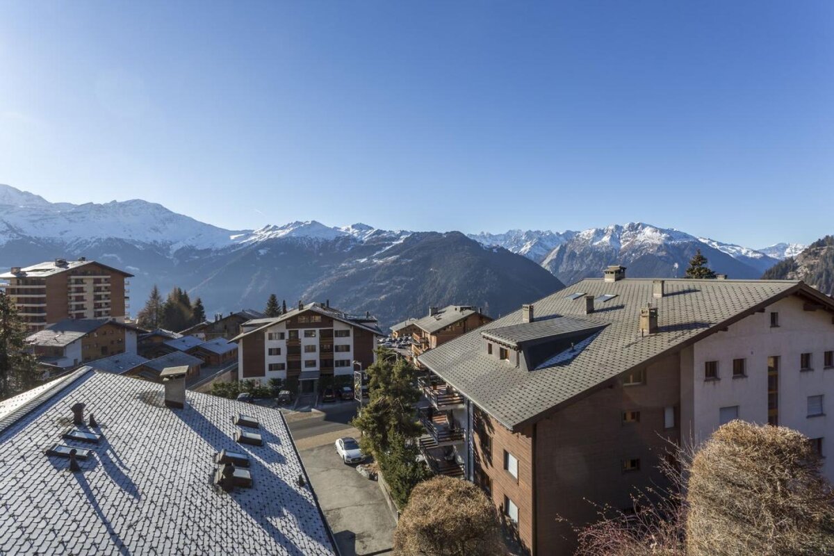 A rooftop view of a city with mountains in the background