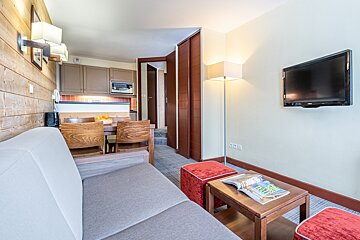 A living room with a couch a table and a flat screen tv