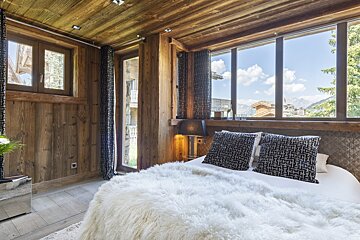 A bedroom with a bed and a large window