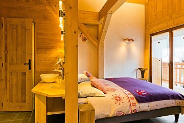 A bedroom with a purple comforter and a sink