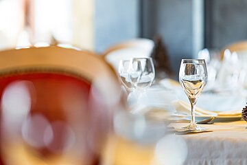 Empty wine glasses on a table with a red chair in the background
