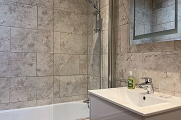 A bathroom with a sink and a bottle of olive oil soap