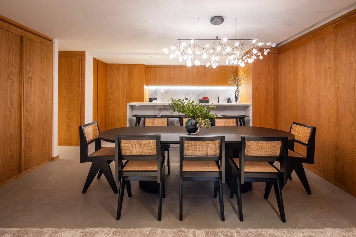 A dining room with a table and chairs and a chandelier