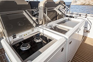 A stove and sink on a boat with a warning sign