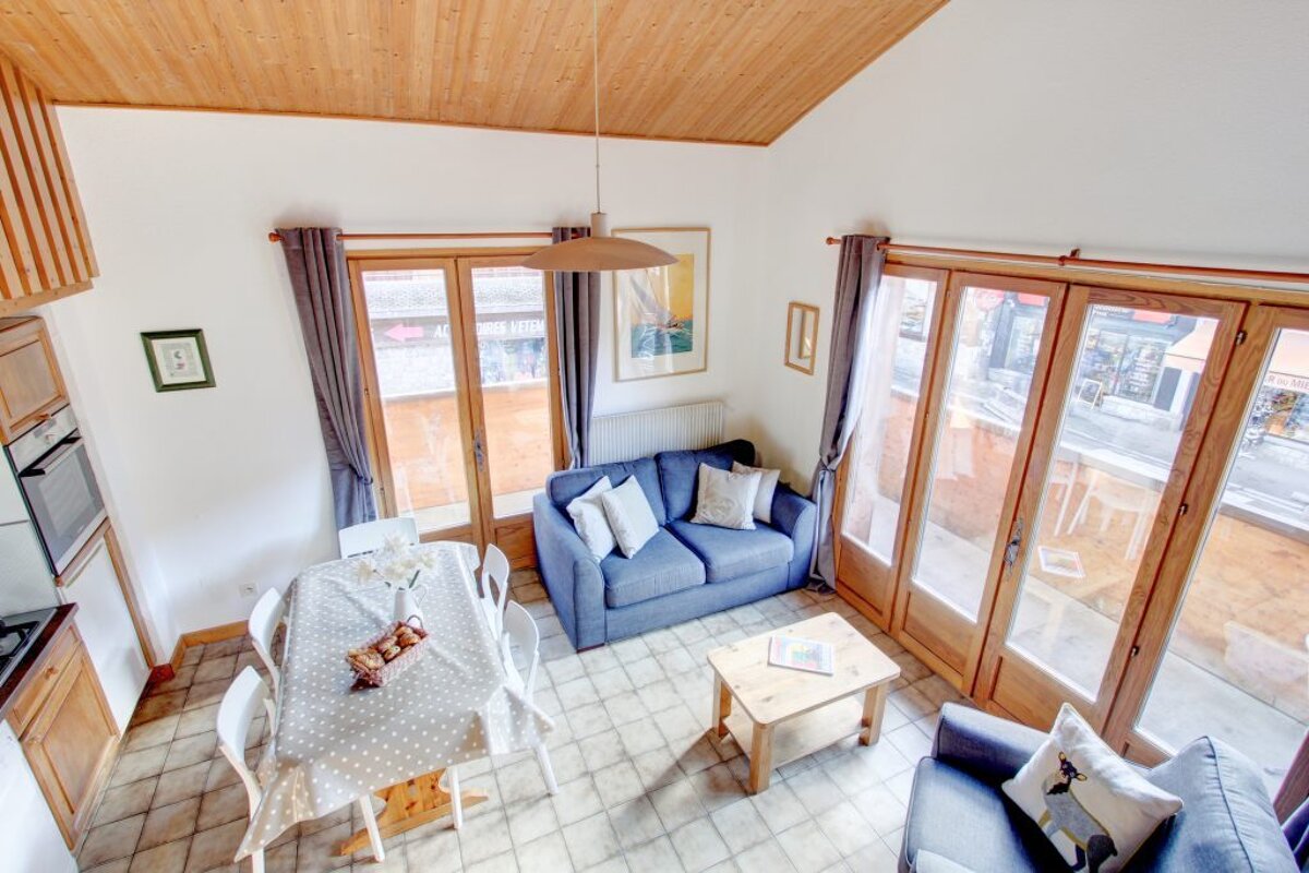 A living room with a blue couch and a table