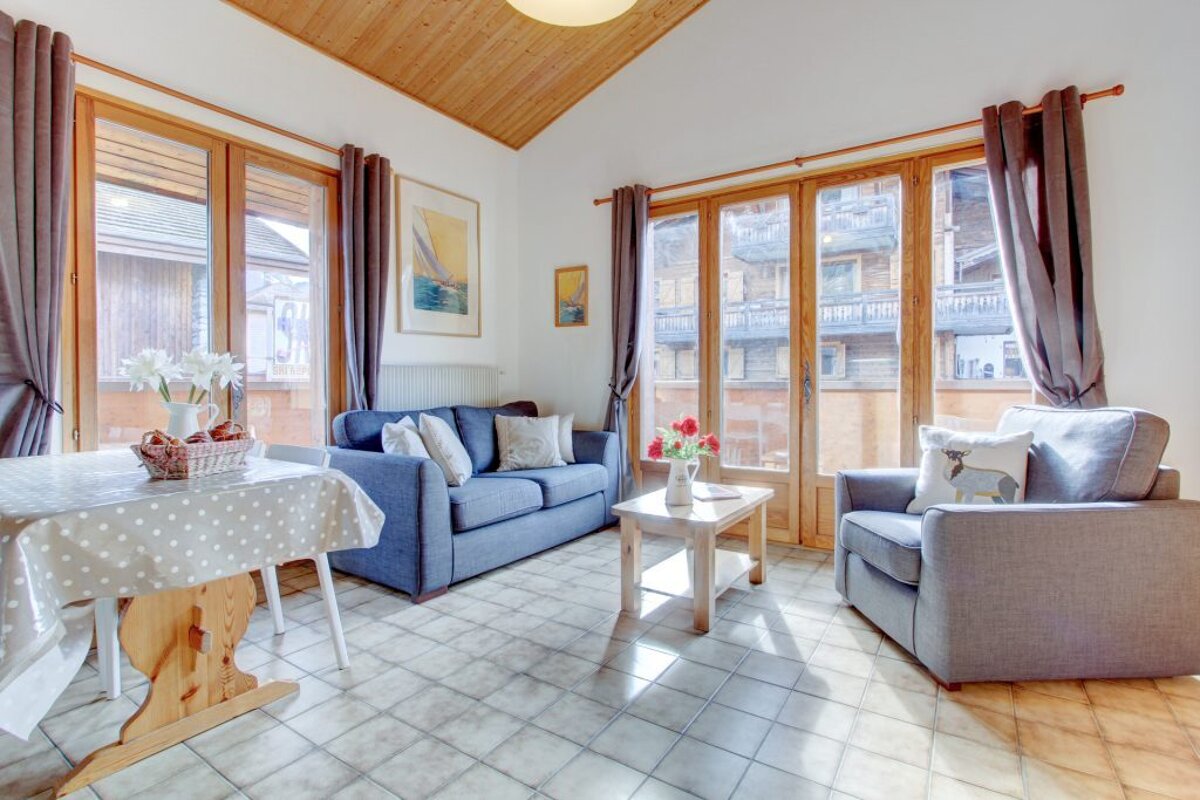 A living room with a blue couch and two chairs