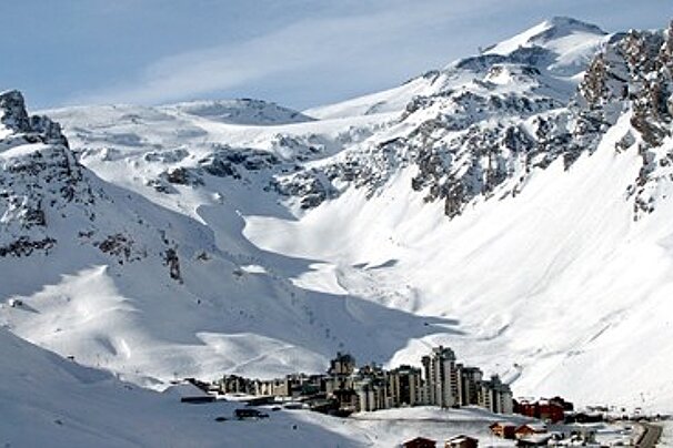 A snowy mountain with a ski resort in the foreground
