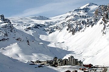 A snowy mountain with a ski resort in the foreground