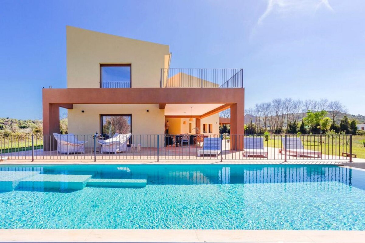A large house with a swimming pool in front of it