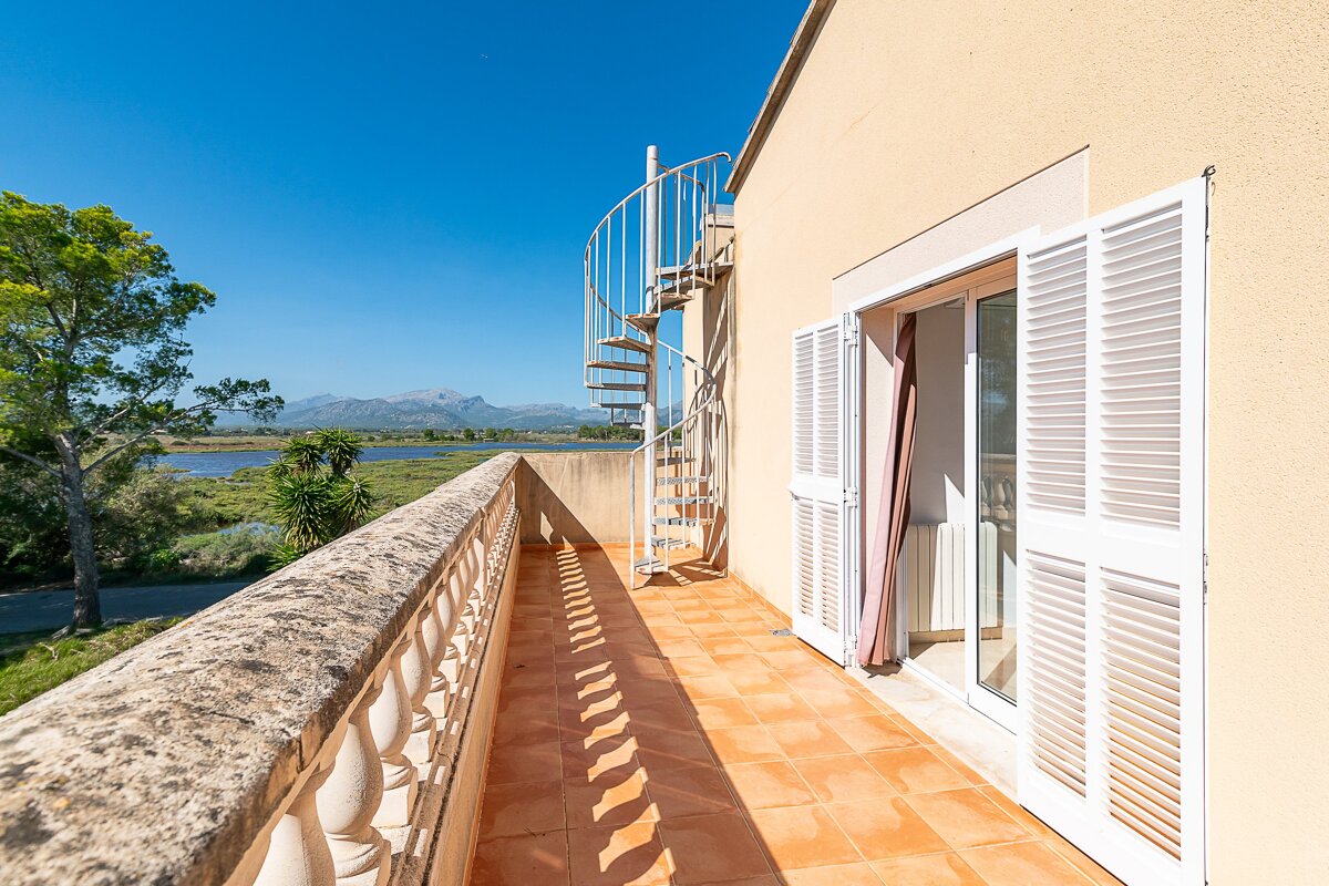 A balcony with a spiral staircase leading up to the second floor