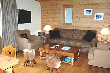 A living room with a couch , chairs , table and television