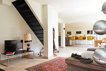 A living room with a staircase and a flat screen tv
