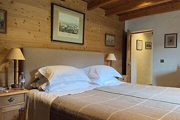 A bedroom with a bed and a picture on the wall