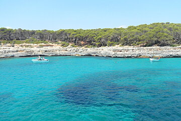 photo of small bay with very blue water and two boats