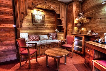 A wooden room with two chairs and a table