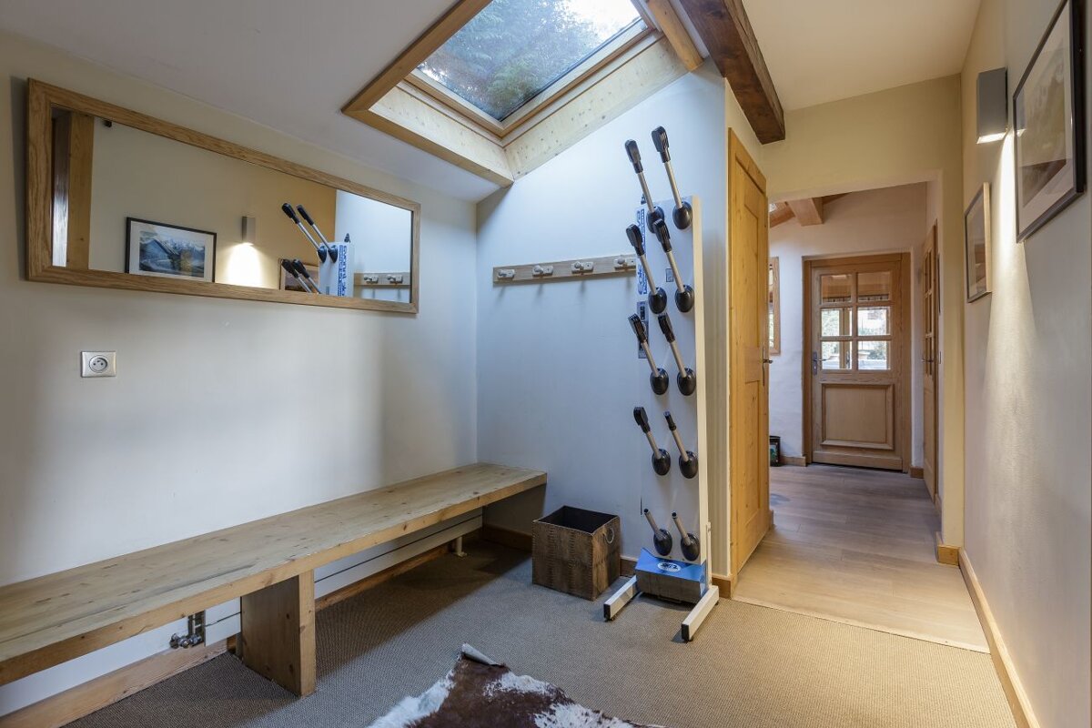A hallway with a bench and a boot dryer