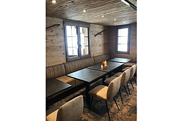 A row of tables and chairs in a room with a wooden ceiling