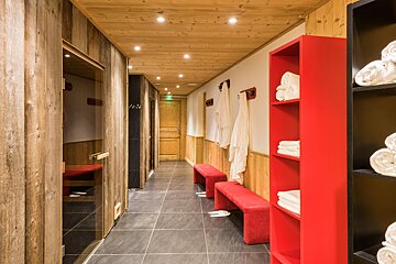 A hallway with a red shelf full of towels