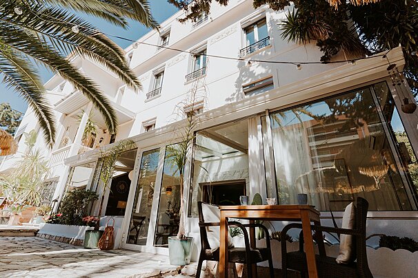 A large white building with a table and chairs in front of it