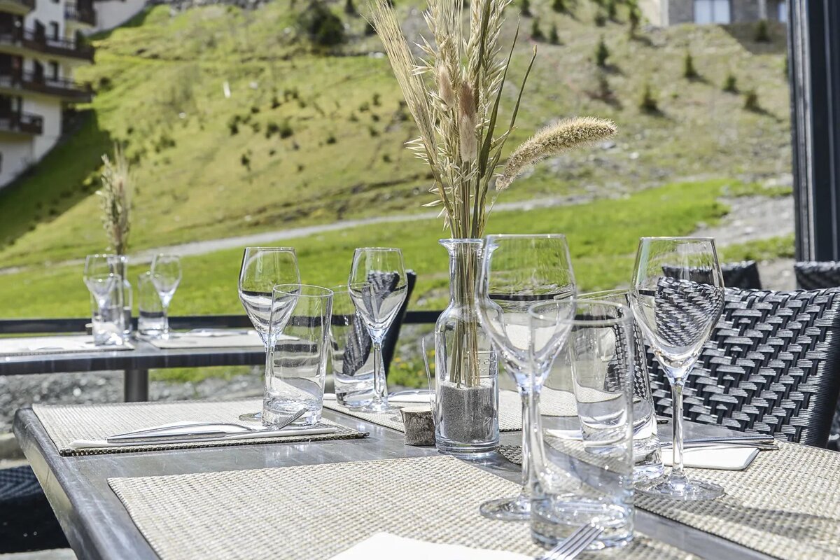 A table with glasses and a vase with flowers on it