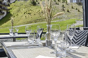 A table with glasses and a vase with flowers on it