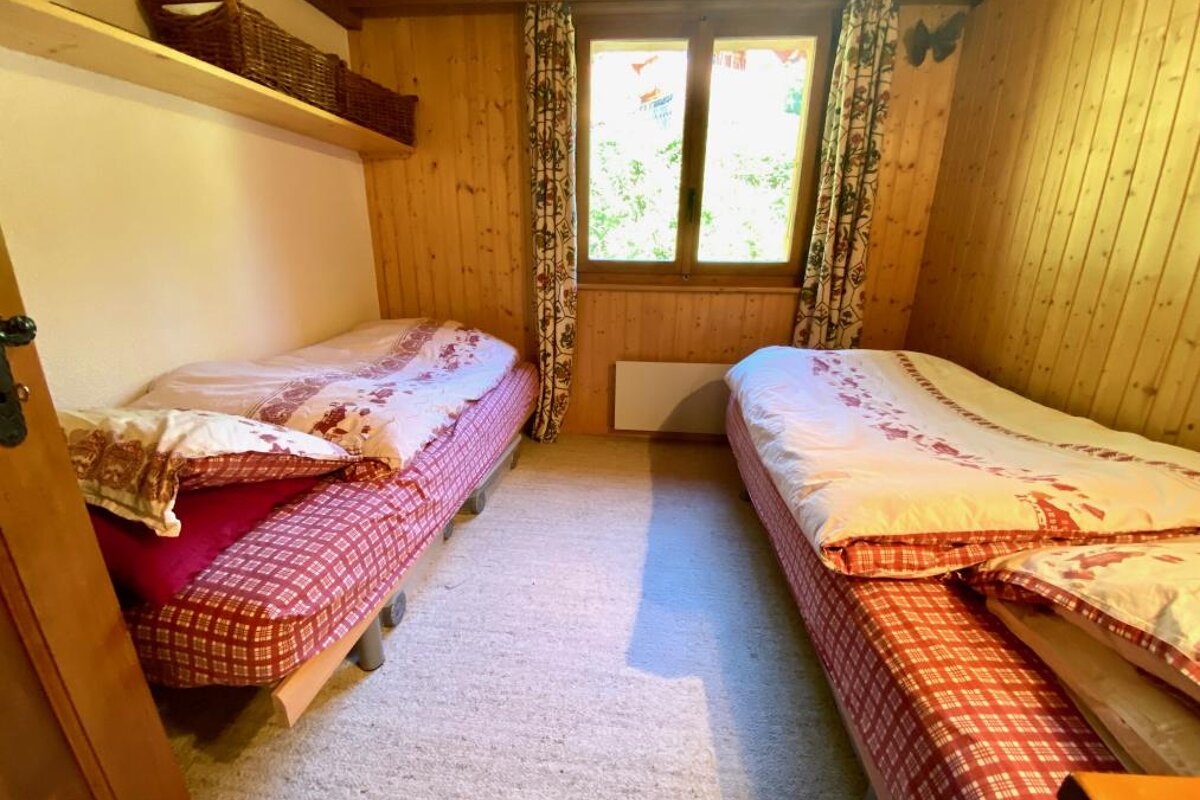 A bedroom with two beds and a window