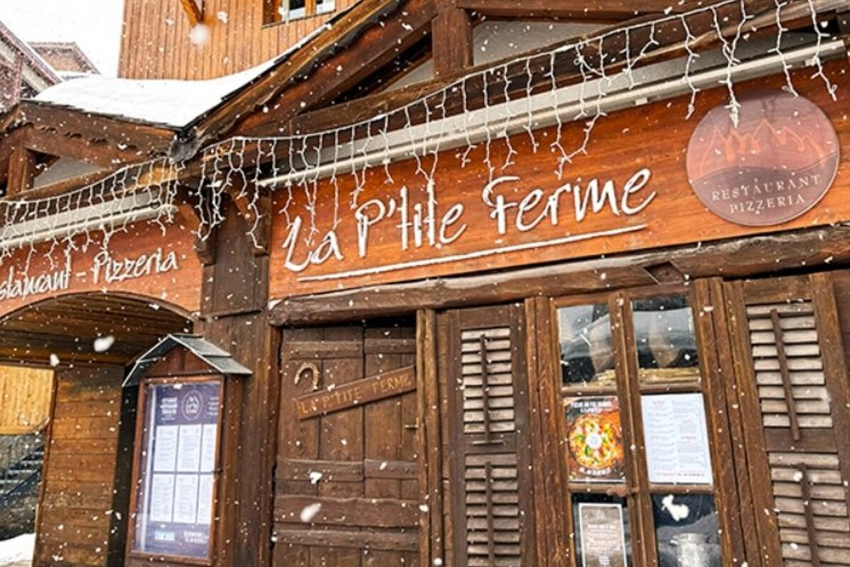 A restaurant called la petite ferme is covered in snow